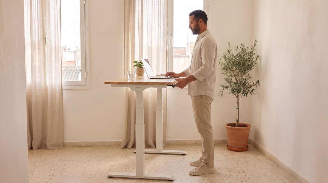 Homme marocain travaillant debout, le dos droit, à un bureau assis-debout électrique PROBYTE dans un appartement au Maroc