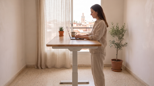 Femme travaillant debout à un bureau assis-debout PROBYTE blanc avec plateau rubberwood, dans un appartement au Maroc